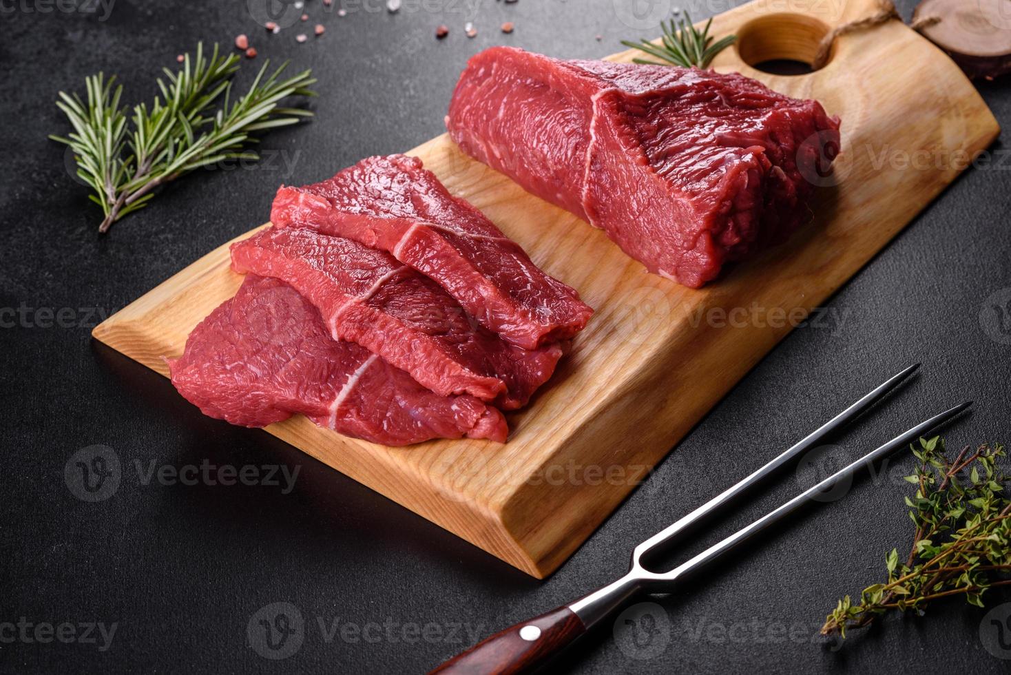 färskt rått nötkött för att göra utsökt saftig biff med kryddor och örter foto