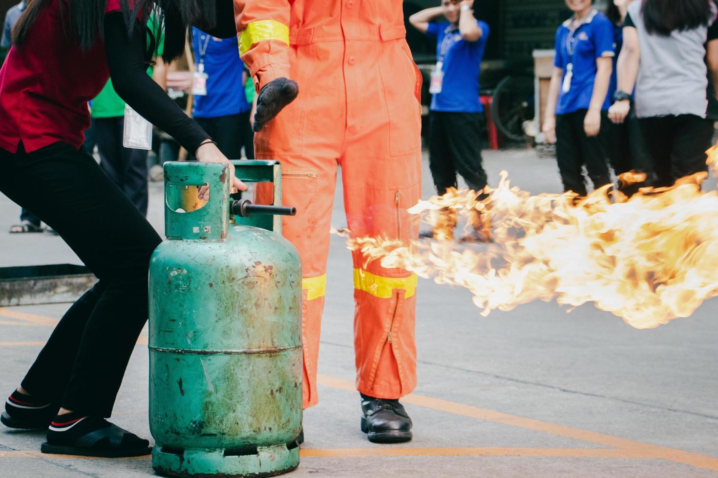 anställd brandbekämpningsträning, stäng av gasbehållarventilen som tänds. foto