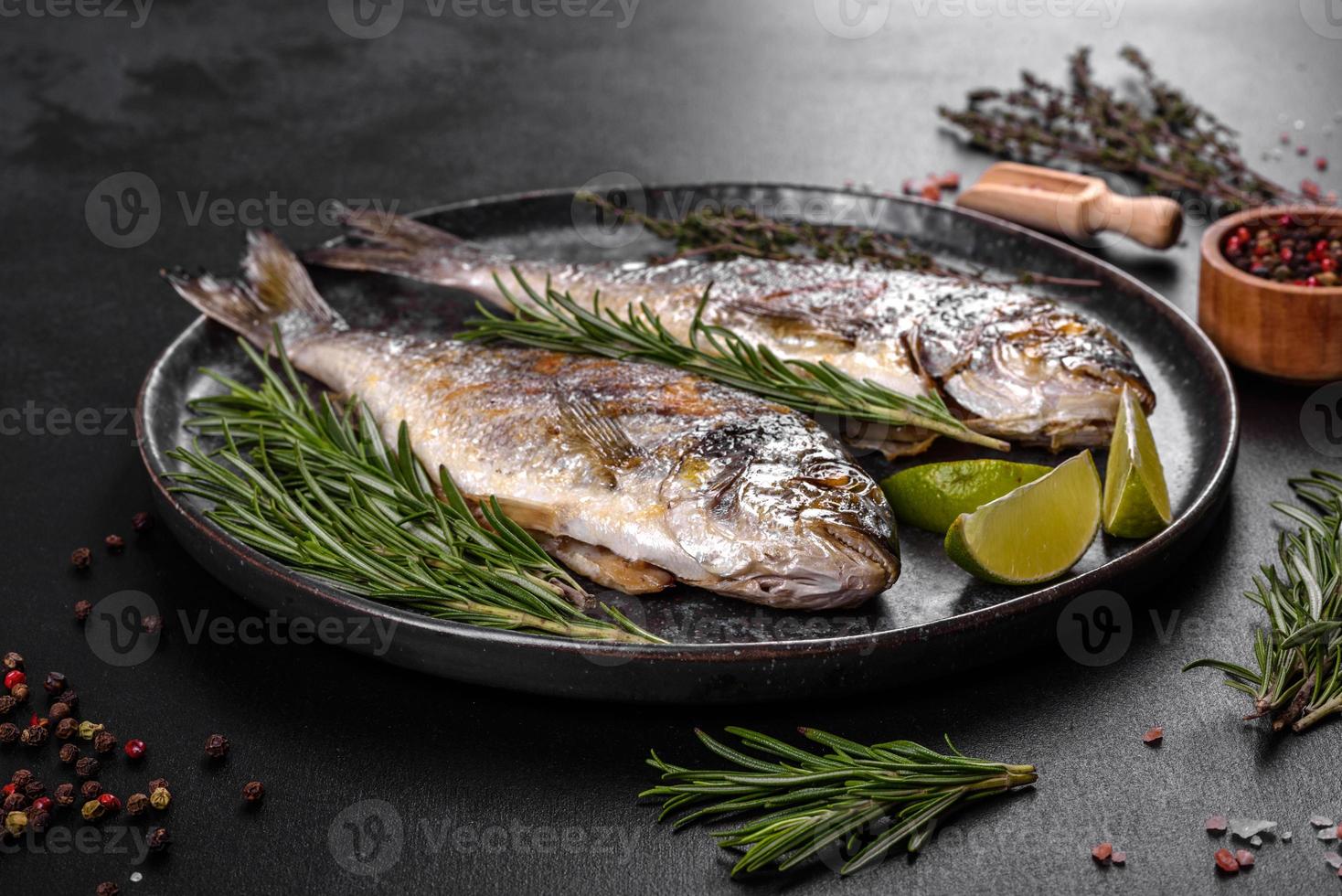 läcker dorado bakad på en grill med kryddor och örter. dorado tillagas på ungefär foto