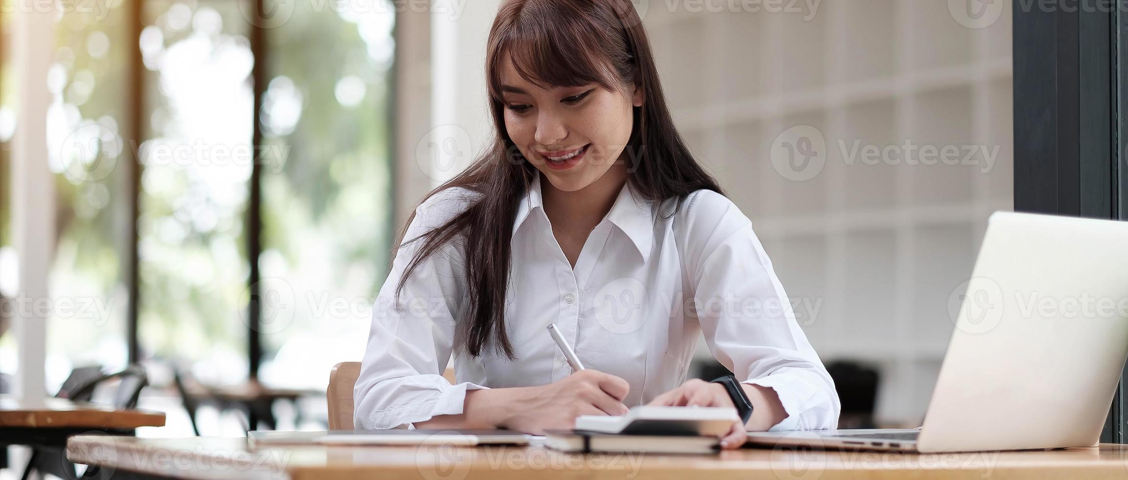 porträtt av en ganska ung kvinna som studerar medan du sitter vid bordet foto