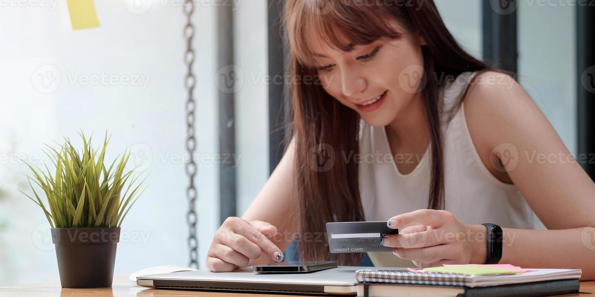 leende kvinna använder mobiltelefon för shopping online med kreditkort foto