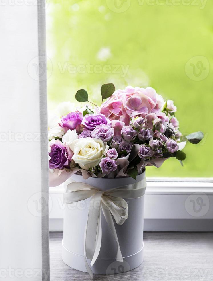 vackra blommor i en vit rund låda foto
