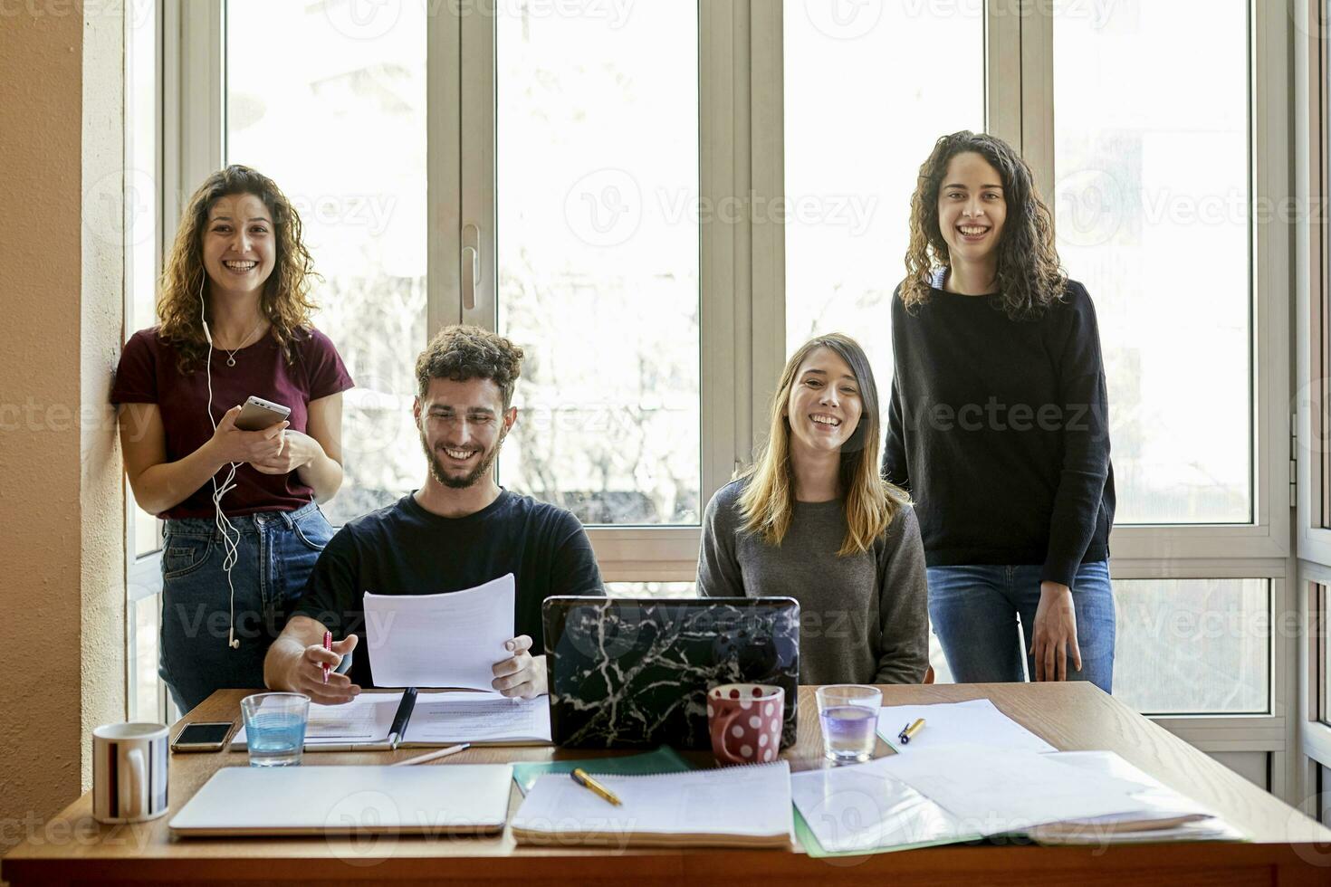 porträtt av fyra Lycklig studenter på skrivbord och på de fönster foto