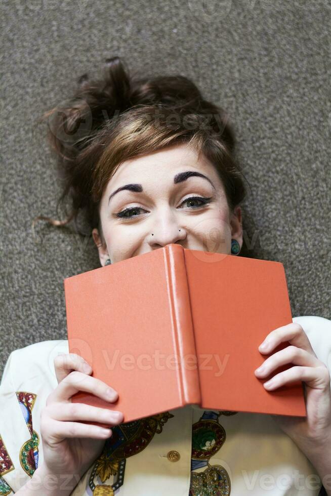 kvinna studerande läsning bok i en offentlig bibliotek foto