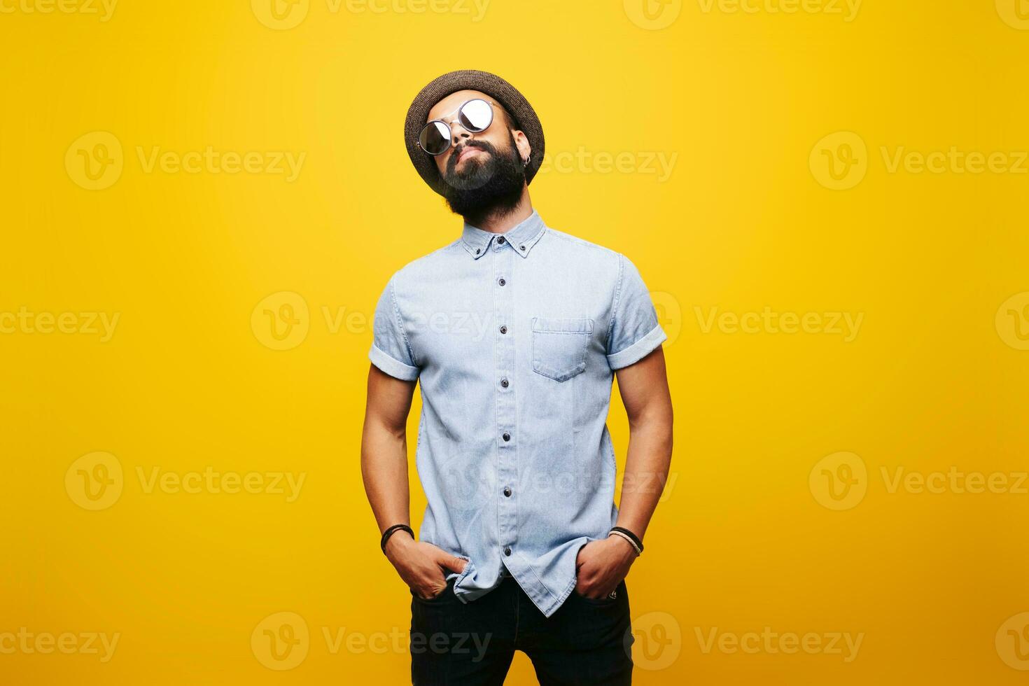 porträtt av en eleganta ung man i studio bär solglasögon foto
