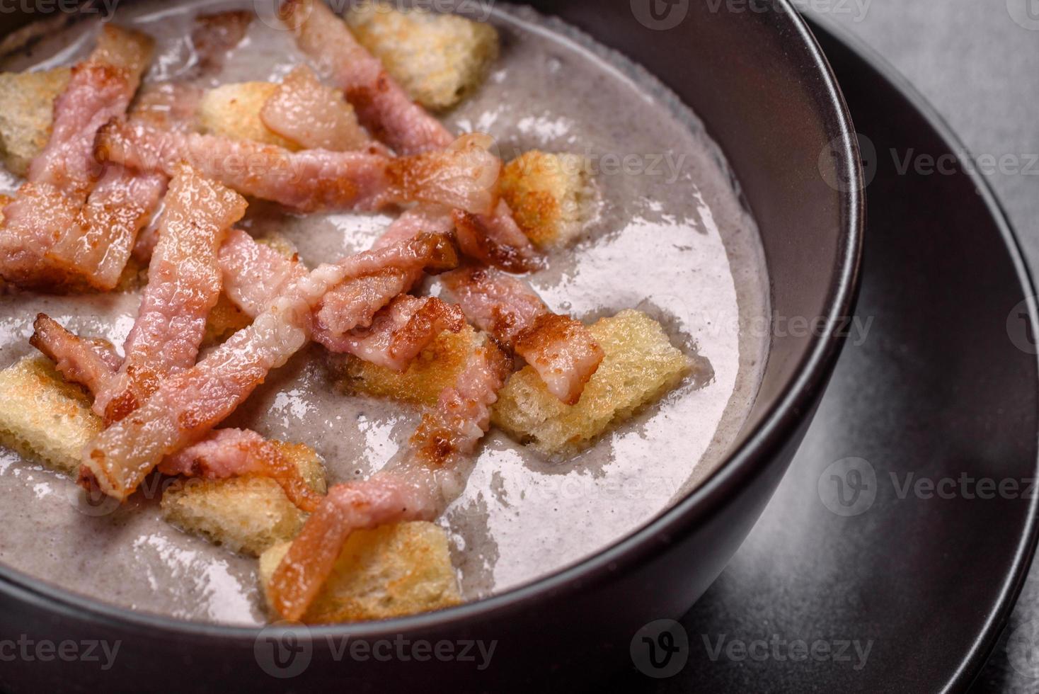 färsk läcker varm puré soppa med svamp och bacon i en svart tallrik foto