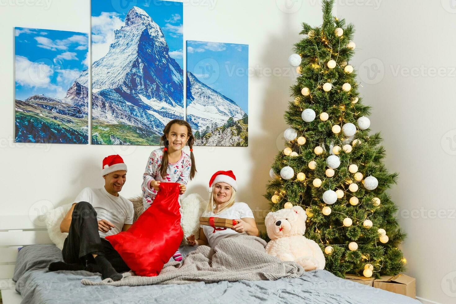 Lycklig familj på Hem. mor, far och barn liggande i de säng med jul gåva. vinter- Semester begrepp foto