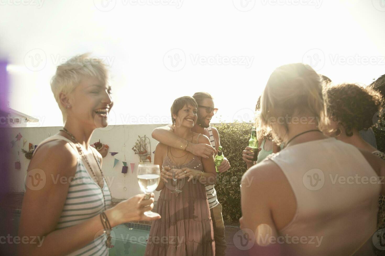 kvinna och manlig vänner njuter sommar medan dricka alkohol mot himmel foto