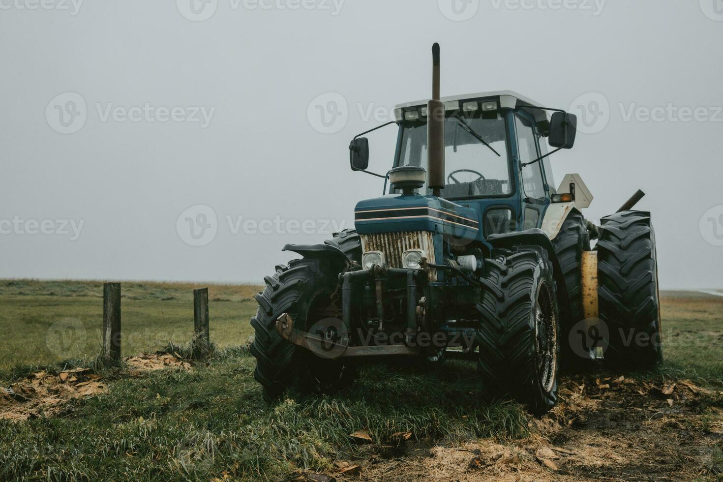 blå gammal övergiven traktor för bärande turister till de mando ö, på de Strand av nordlig hav i Danmark under de molnig höst dag foto