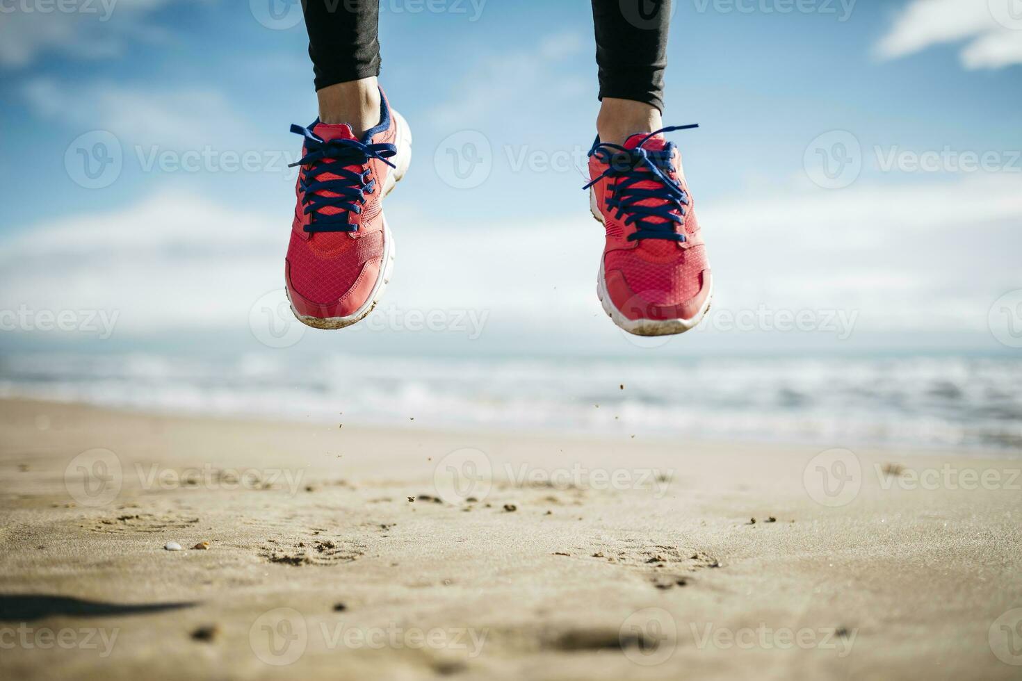 fötter av kvinna Hoppar på strand foto