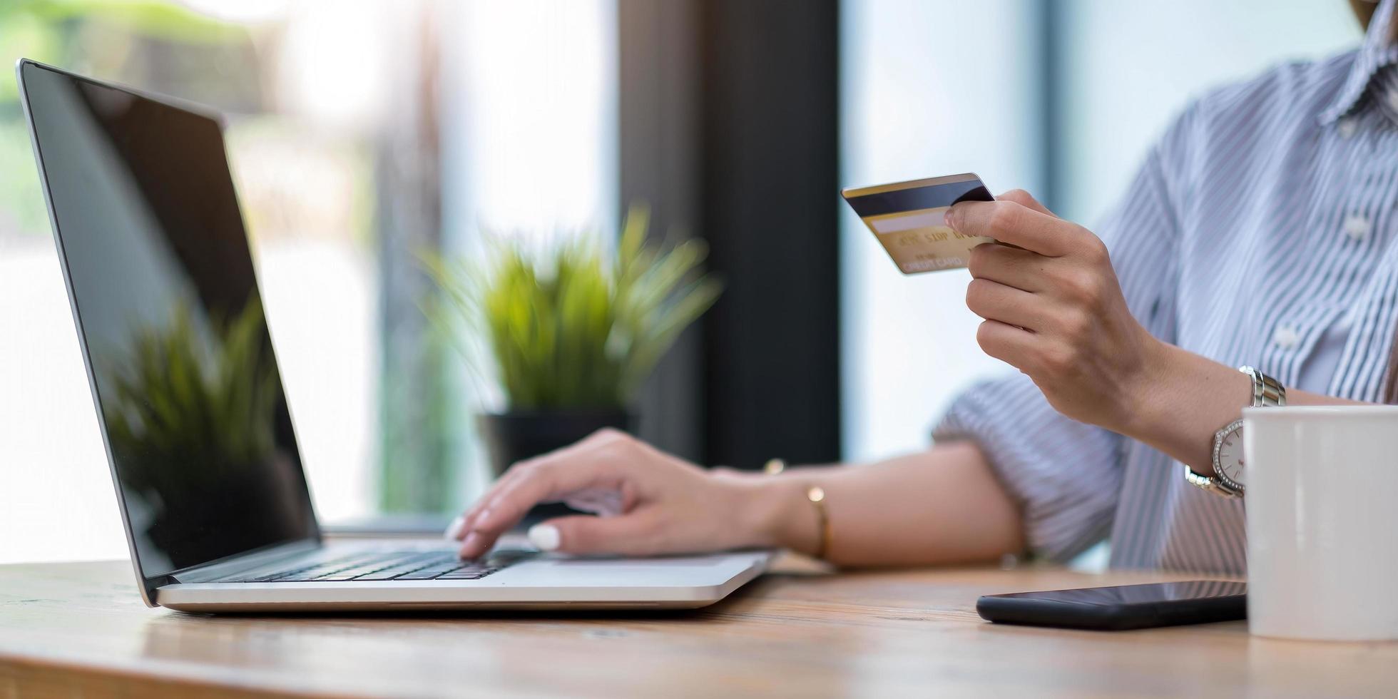 kvinna som använder datorn och håller kreditkortet för online-shopping foto