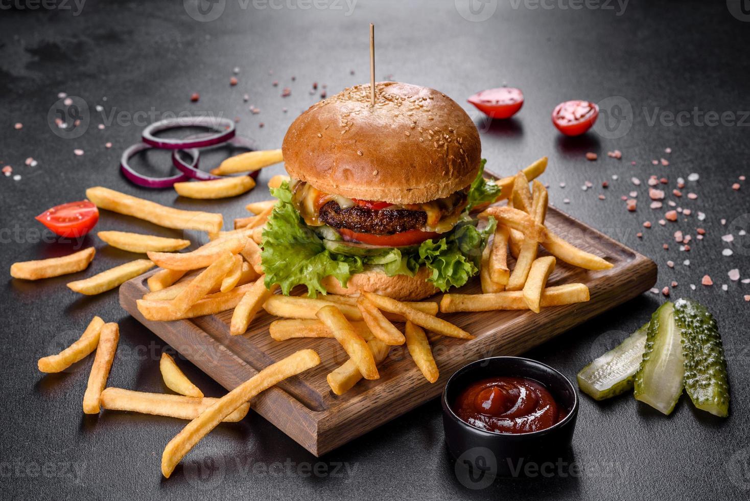 läcker färsk burger med nötköttkotlett, tomater och sallad med pommes frites foto