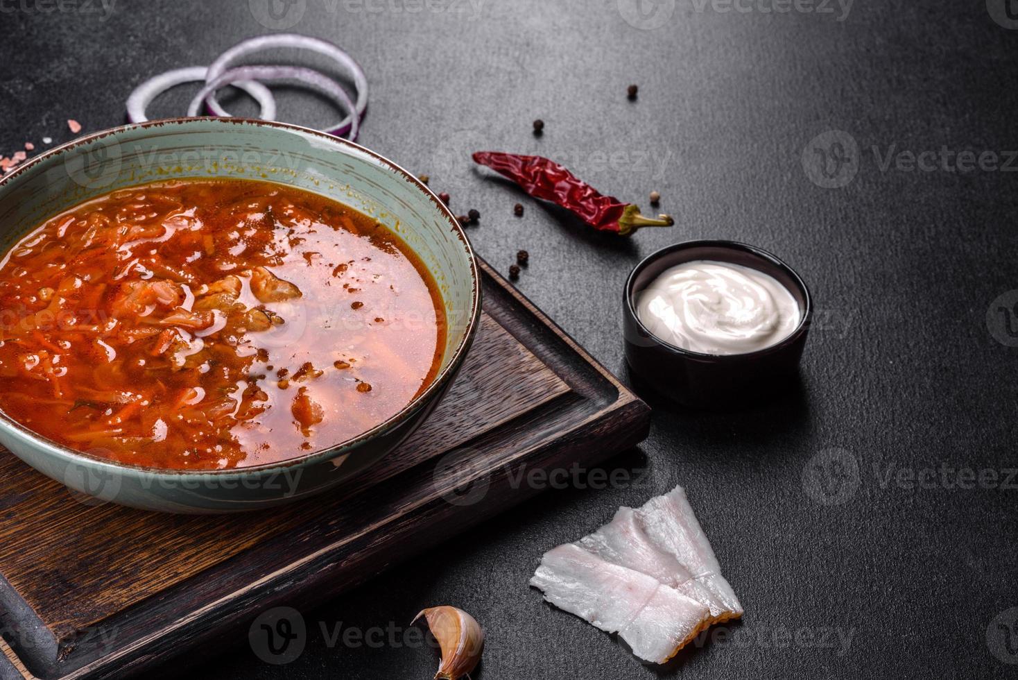 läcker färsk varm borsch med tomat och kött i en keramisk tallrik foto