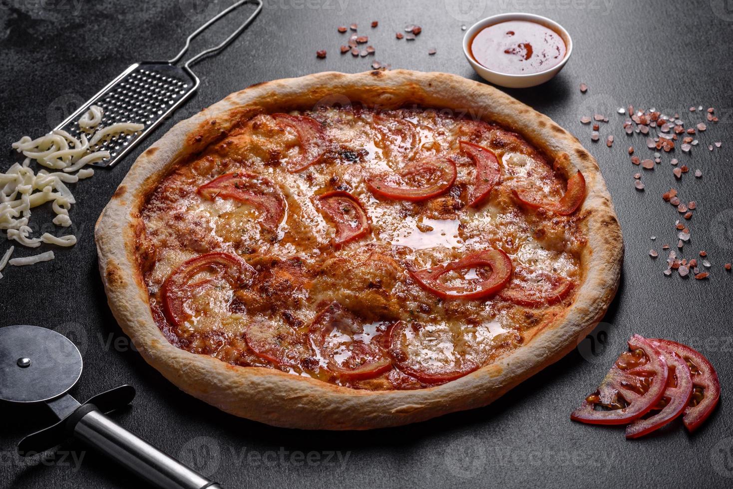 färsk läcker italiensk pizza med svamp och tomater på en mörk betongbakgrund foto