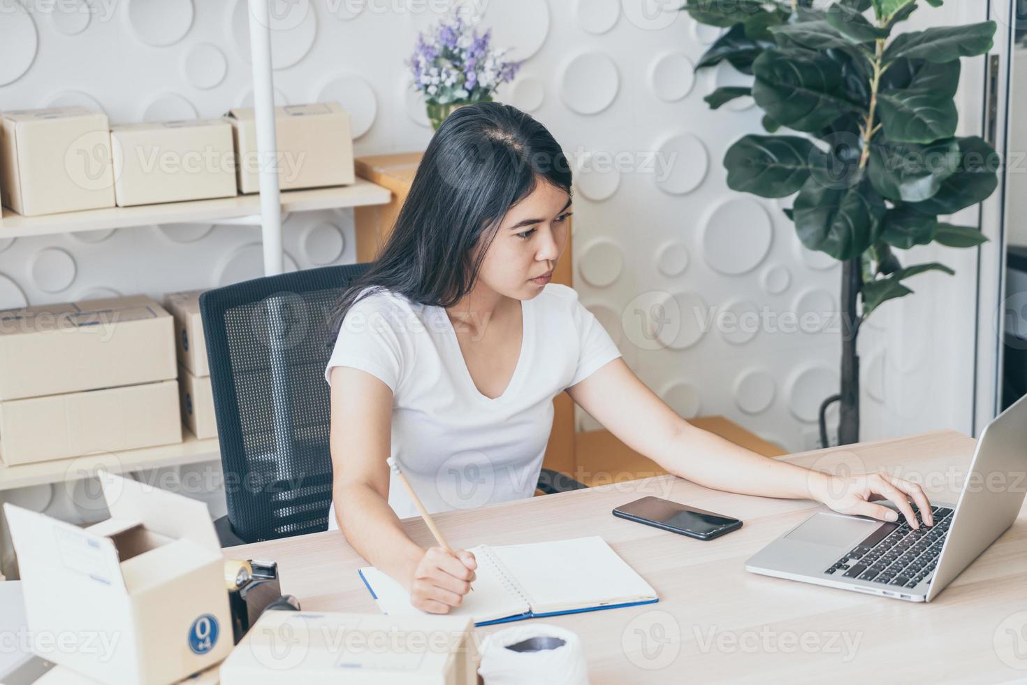 ung asiatisk kvinna som startar upp småföretagare som arbetar med den digitala minnestavlan på arbetsplatsen - online-försäljning, e-handel, fraktbegrepp foto