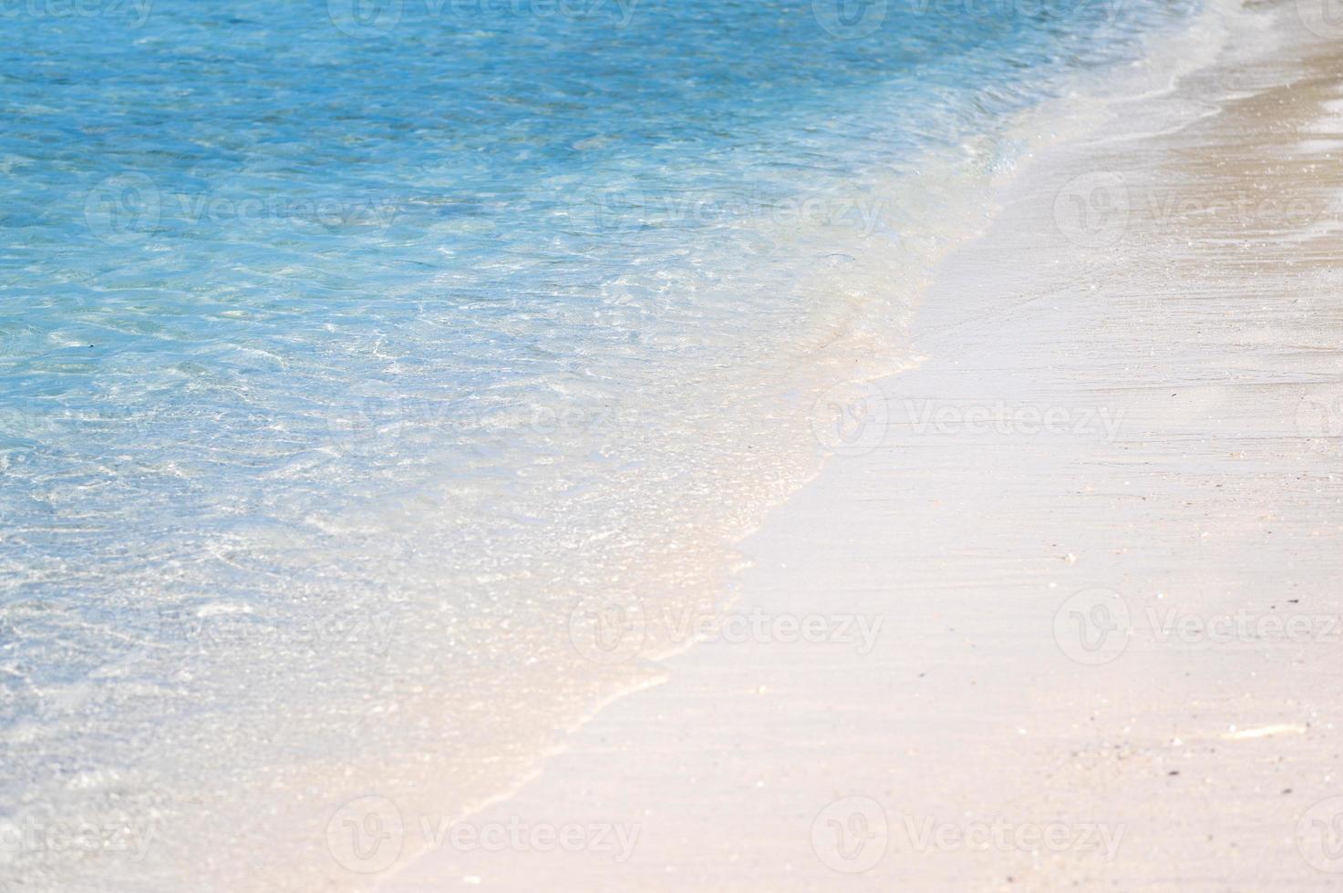 klara havsvågor och vit sandstrand på sommaren. foto