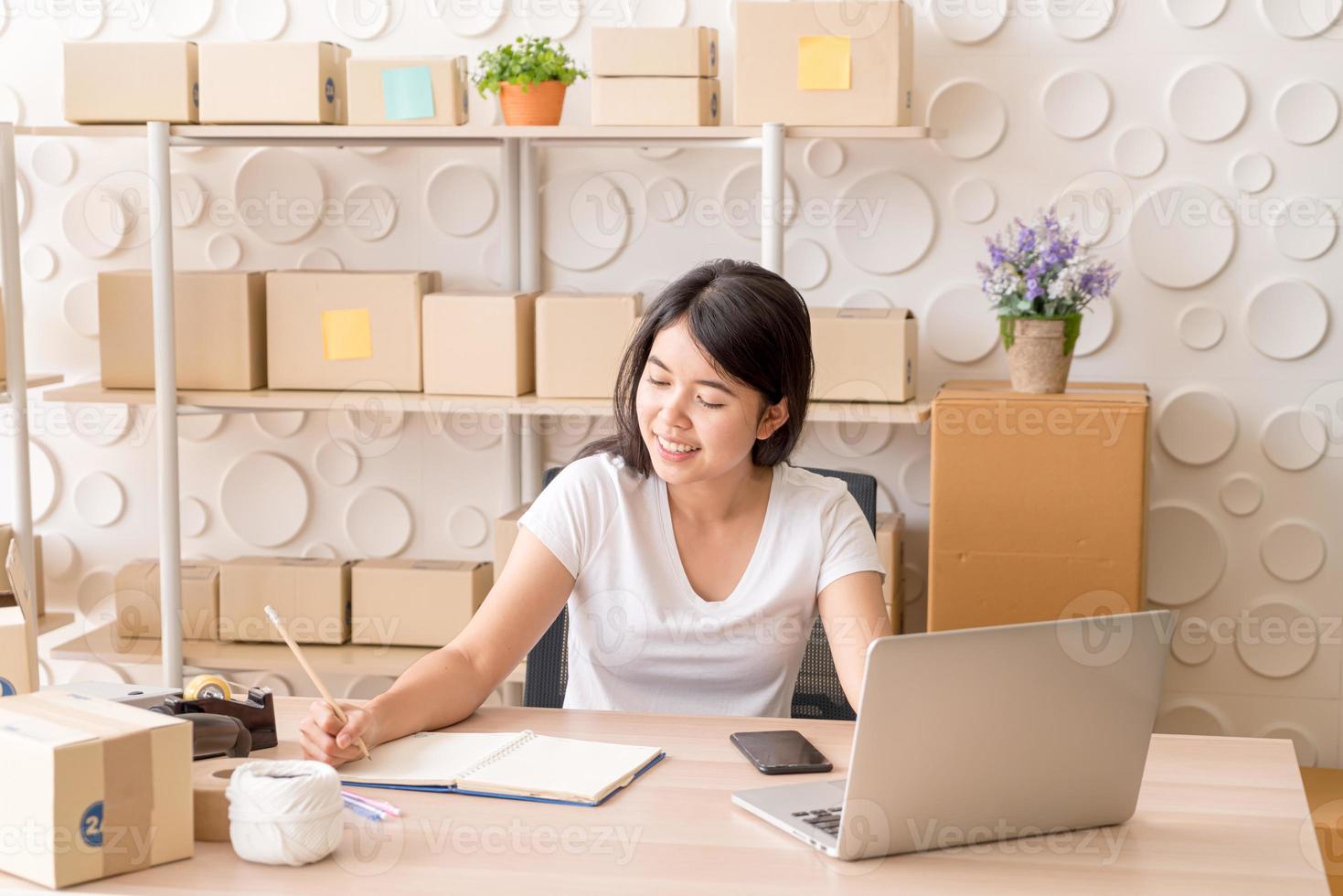 ung asiatisk kvinna som startar upp småföretagare som arbetar med den digitala minnestavlan på arbetsplatsen - online-försäljning, e-handel, fraktbegrepp foto