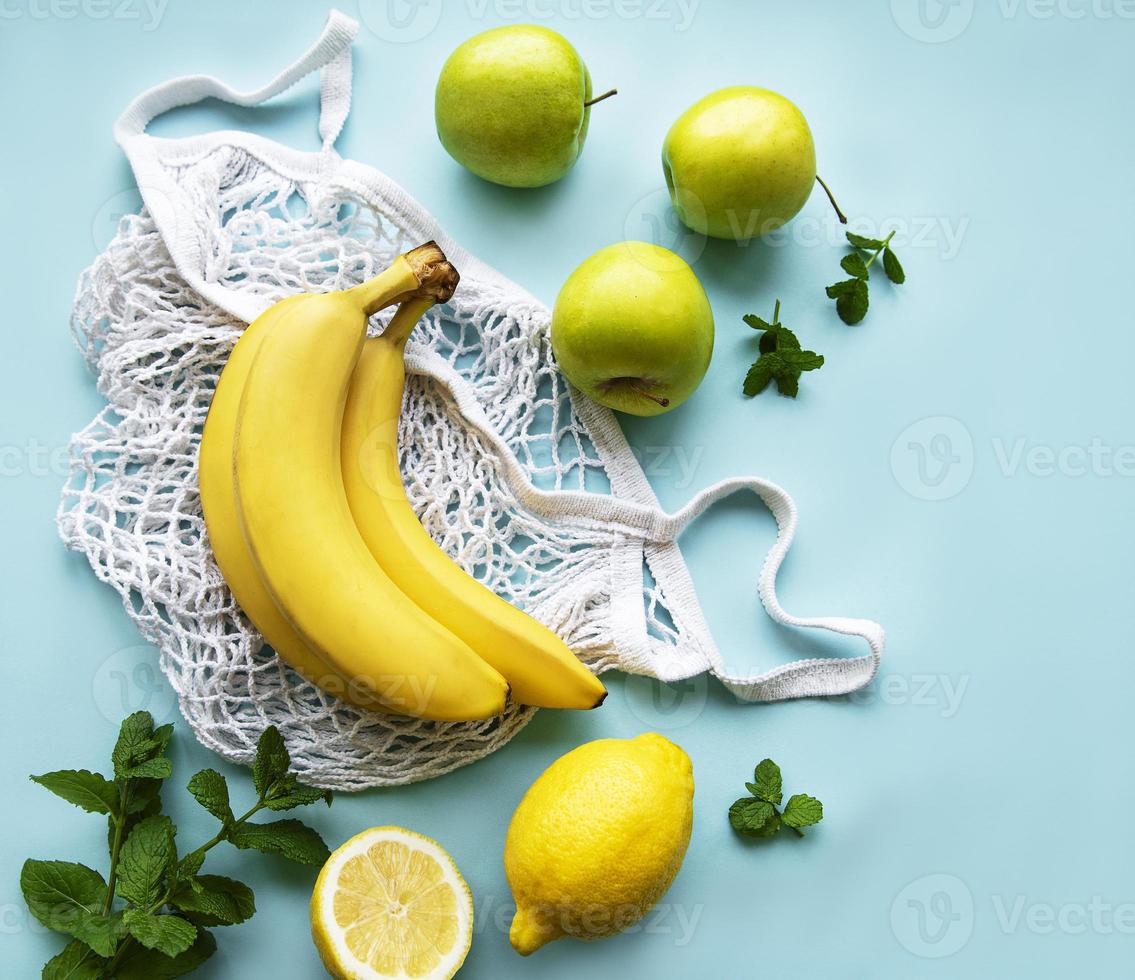 saftiga mogna citrusfrukter och bananer i en miljövänlig shoppingkasse foto