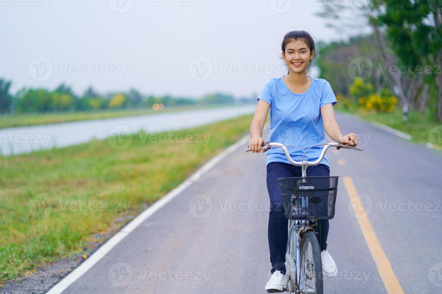 flicka med cykel, kvinna som cyklar på vägen i en park foto