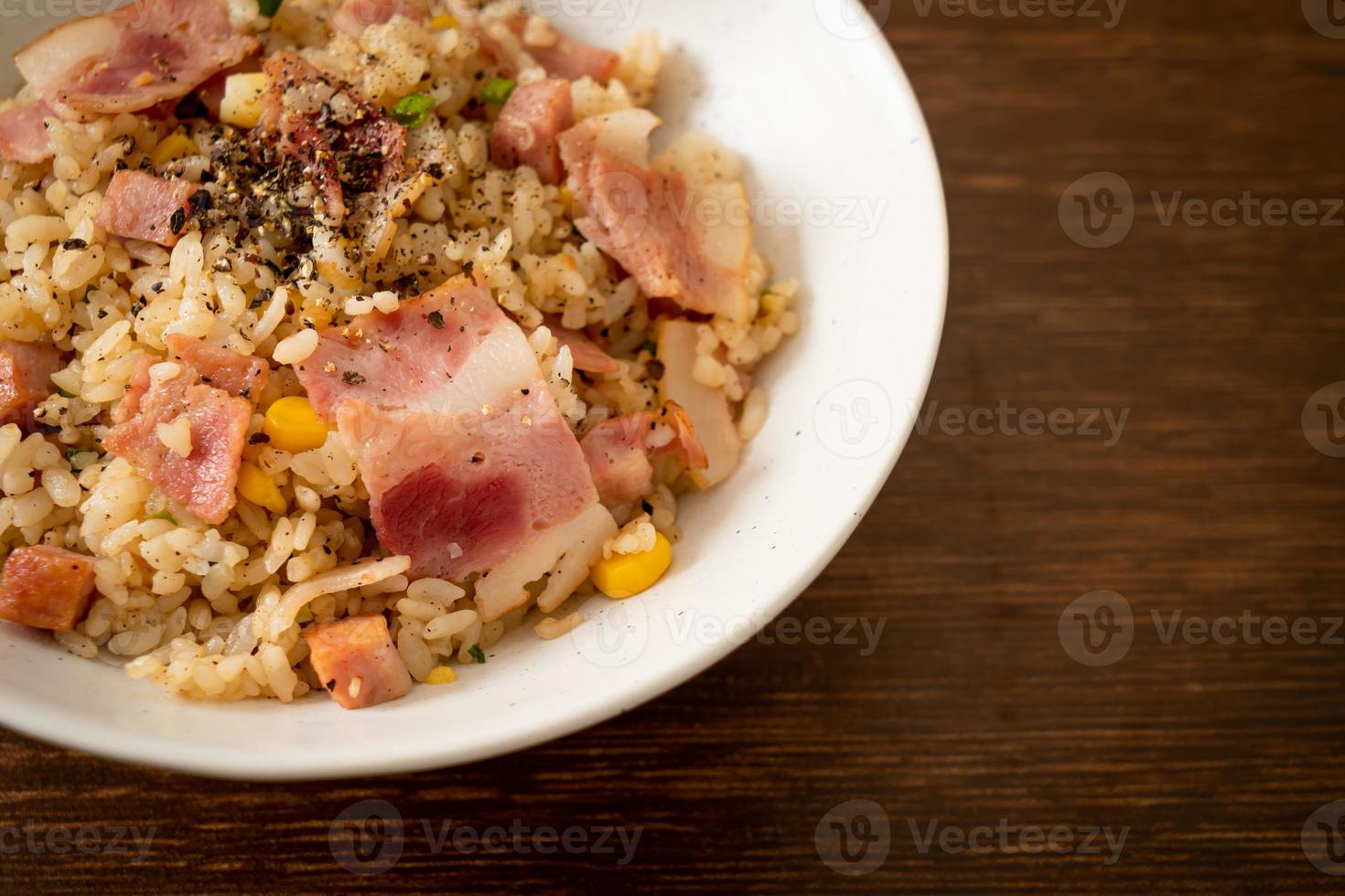 stekt ris med bacon, skinka och svart paprika på vit platta foto