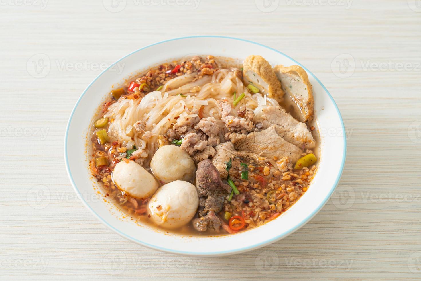 nudlar med fläsk och köttbullar i kryddig soppa eller tom yum nudlar i asiatisk stil foto