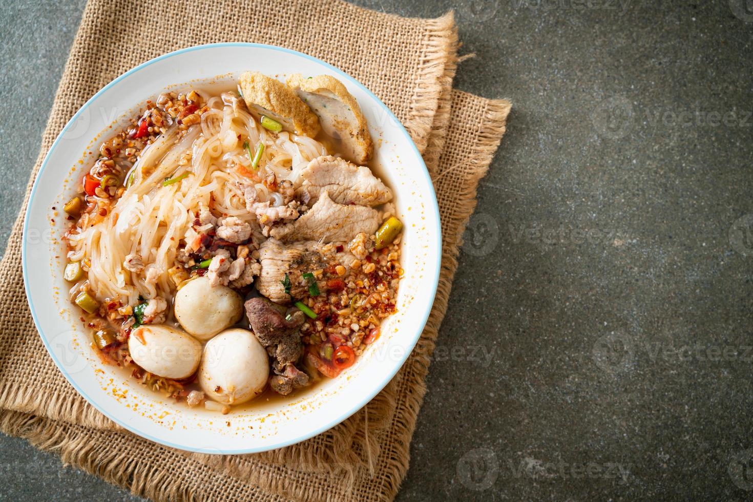 nudlar med fläsk och köttbullar i kryddig soppa eller tom yum nudlar i asiatisk stil foto