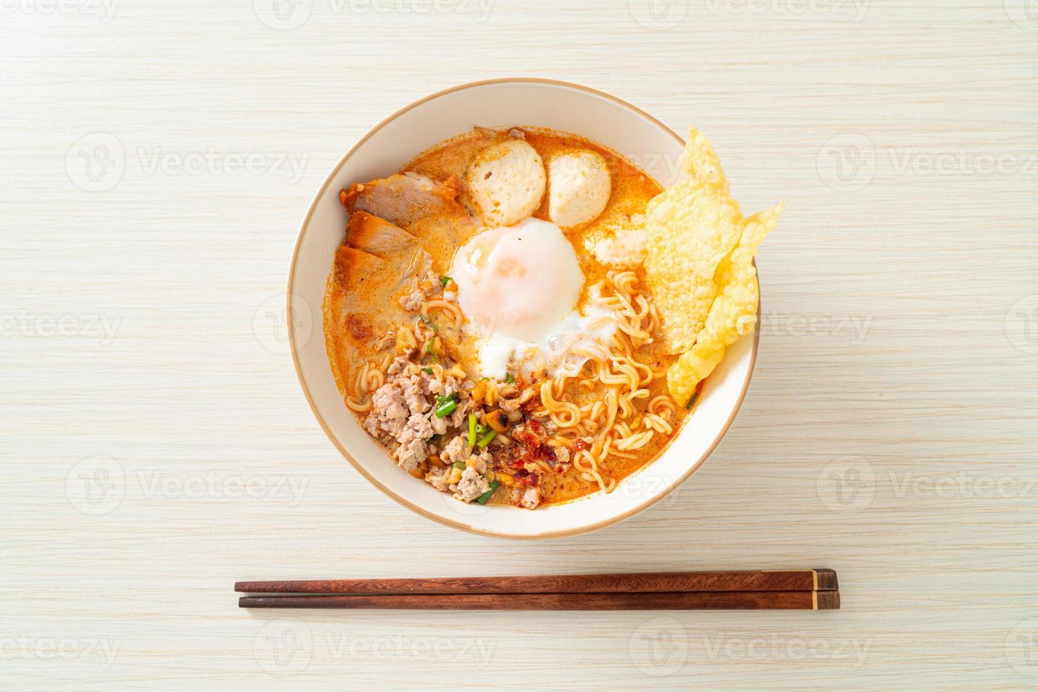 snabbnudlar med fläsk och köttbullar i kryddig soppa eller tom yum-nudlar i asiatisk stil foto