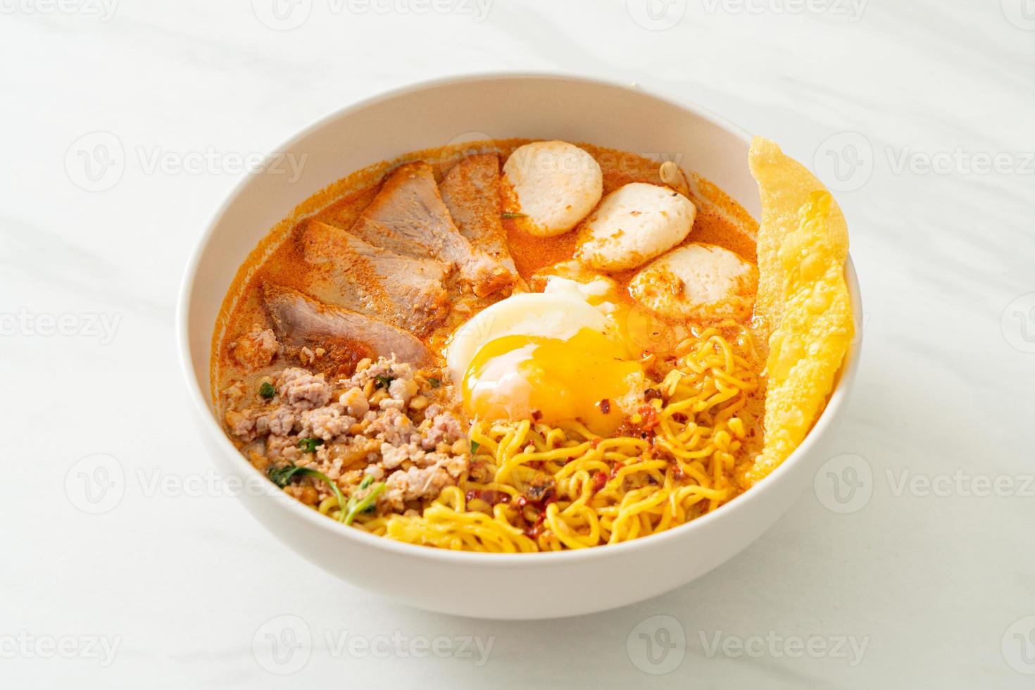 äggnudlar med fläsk och köttbulle i kryddig soppa eller tom yum nudlar i asiatisk stil foto