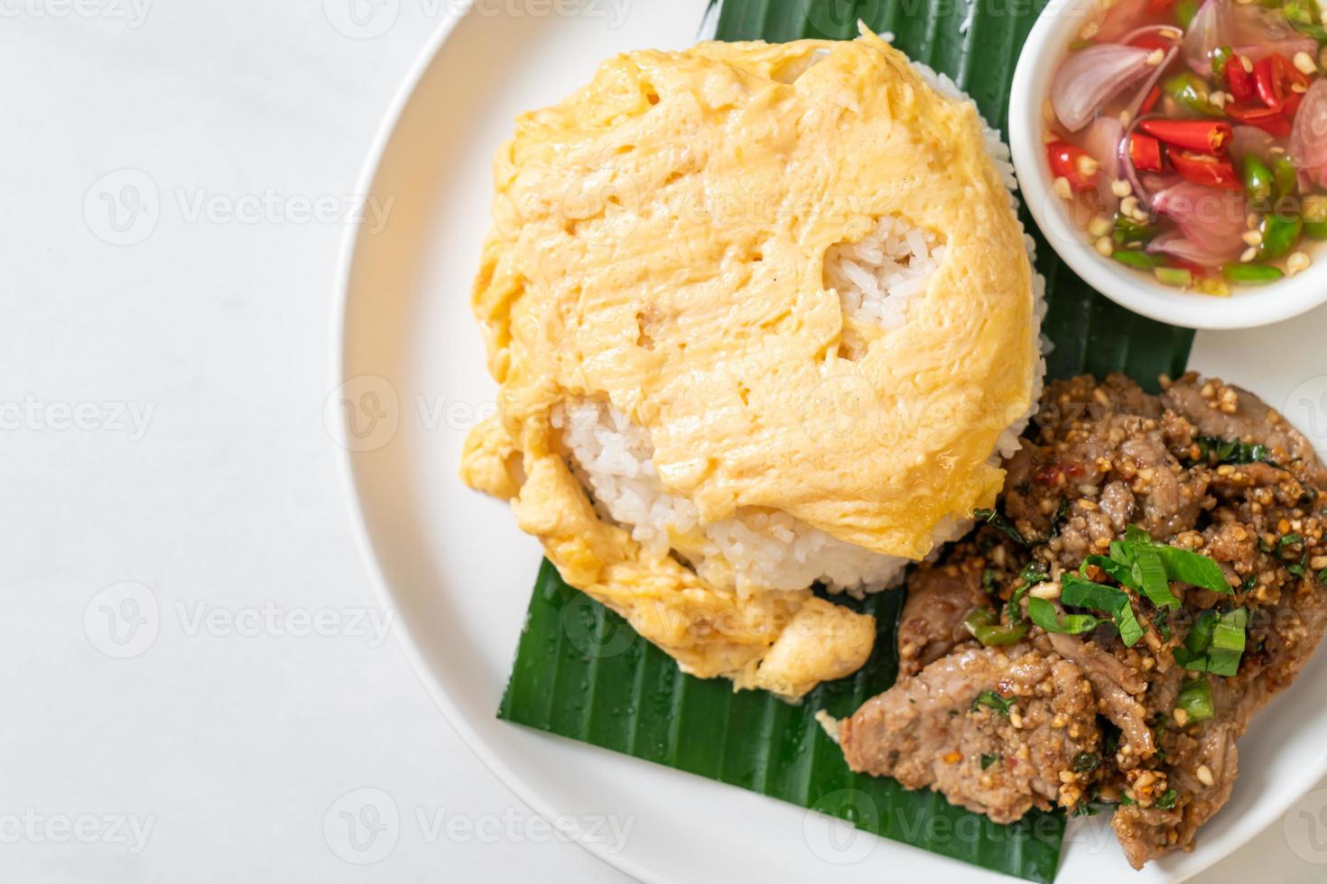 ägg på toppat ris med grillat fläsk och kryddig sås - asiatisk matstil foto