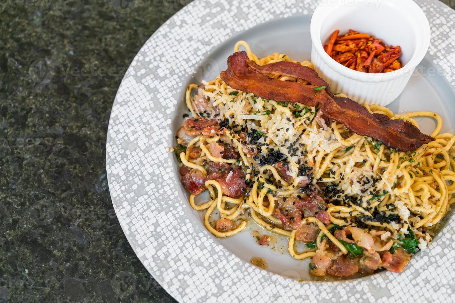 spagetti aglio e olio med bacon - stekt spagetti med vitlök, olivolja, persilja, parmigiano-reggiano ost kastad och bacon foto