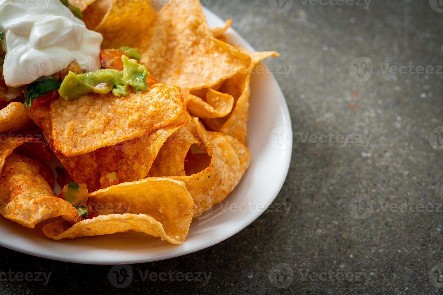 mexikanska nachos tortillachips med jalapeno, guacamole, tomatsalsa och dopp foto