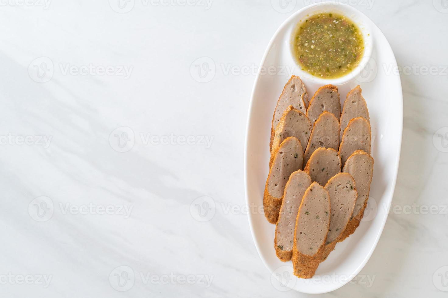 stekt kinesisk fiskkaka eller fiskbolllinje skivad med kryddig skaldjursdoppsås foto