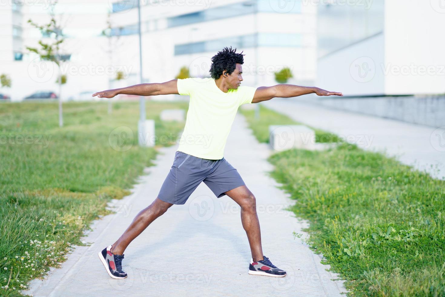 svart man gör krigare 2 eller virabhadrasana ii poserar utomhus. foto