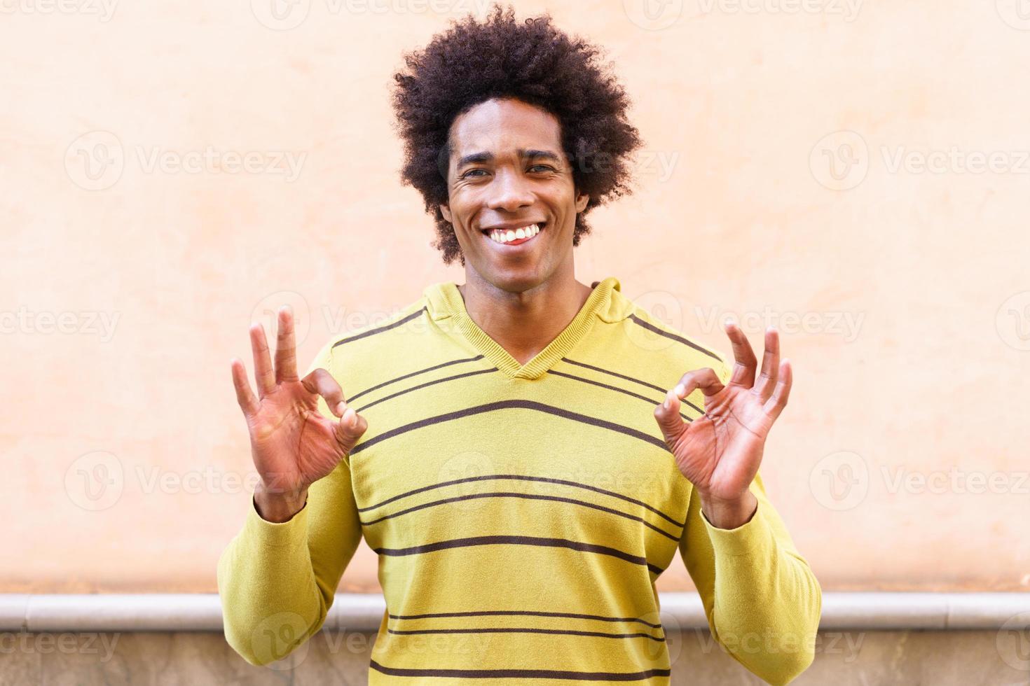 svart man med afro hår sätter ett roligt uttryck foto