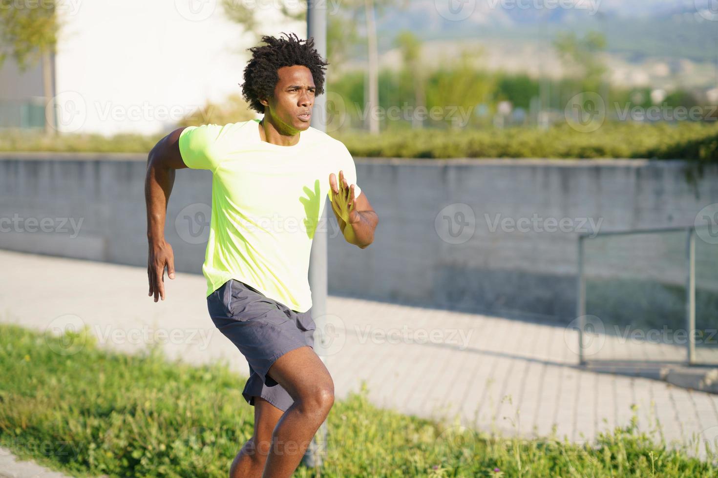 svart atletisk man springer i en urban park. foto