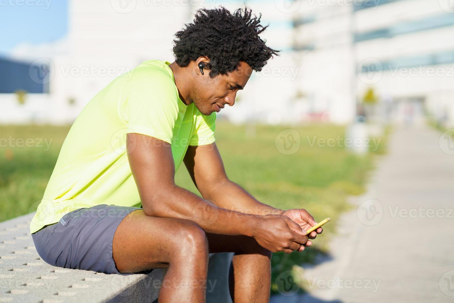 svart man konsulterar sin smartphone med någon träningsapp foto
