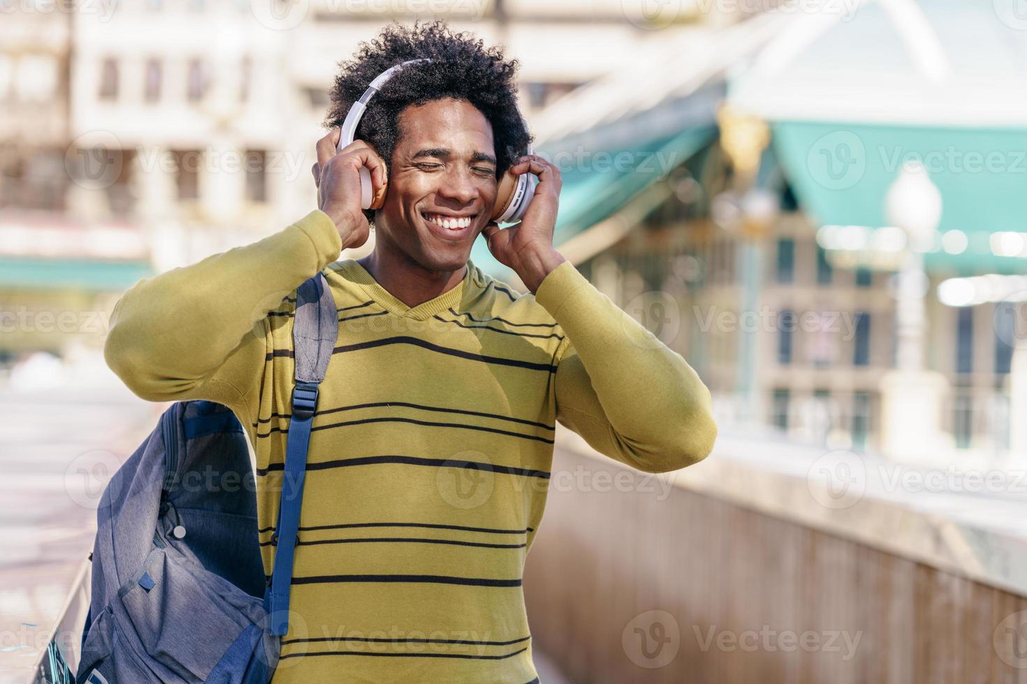 svart man lyssnar på musik med trådlösa hörlurar foto