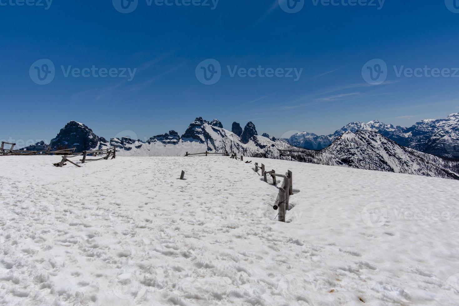 snöiga bellunodolomiter med trästaket foto