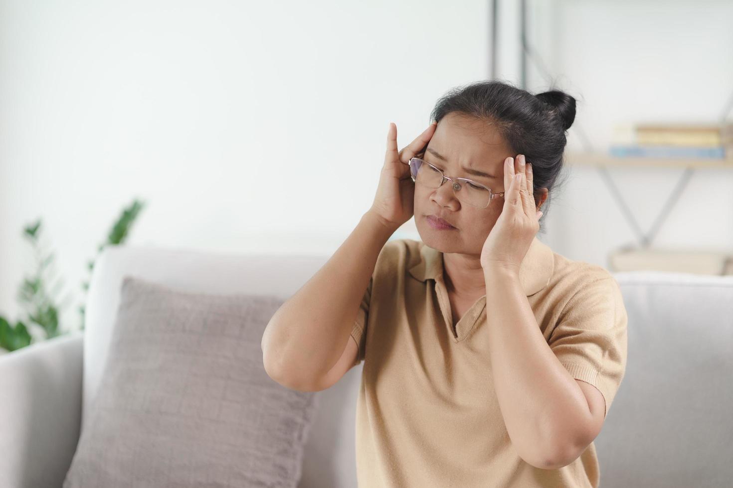 mogen äldre kvinna som lider av huvudvärk, alzheimer koncept. foto