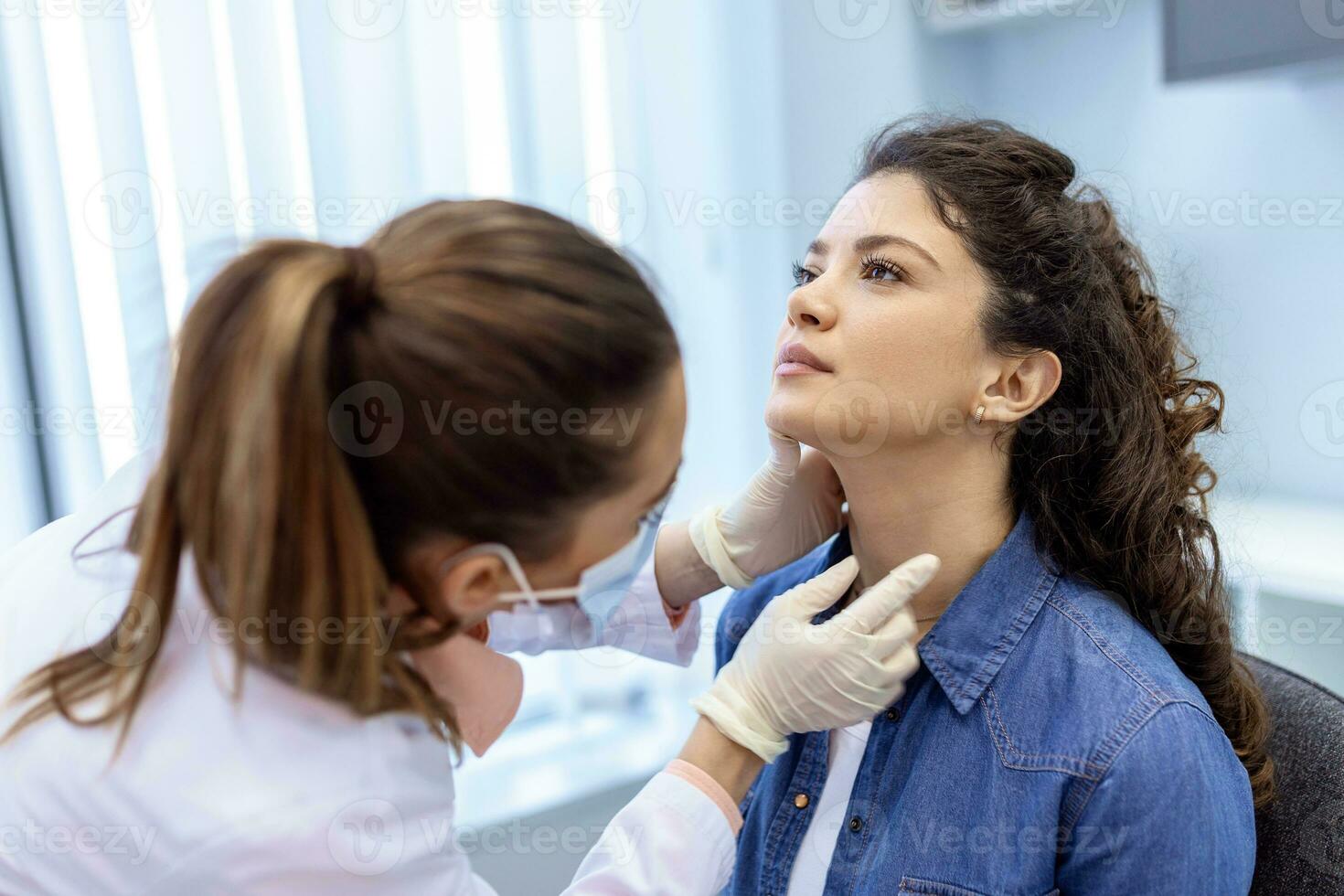 medicin, sjukvård och medicinsk examen begrepp - läkare eller sjuksköterska kontroll patientens mandlar på sjukhus. endokrinolog granskning hals av ung kvinna i klinik foto