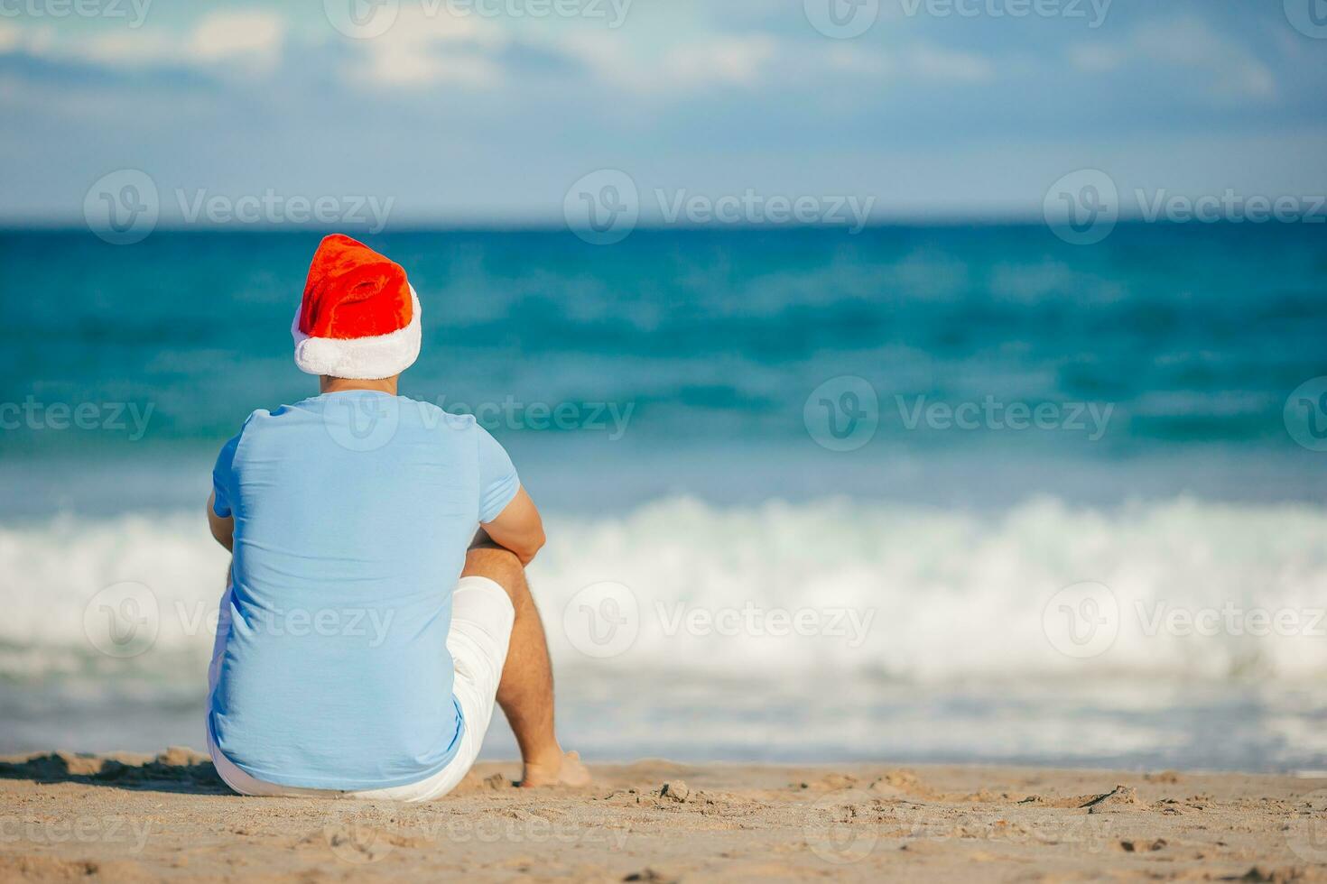 ung man i santa hatt på jul strand högtider foto