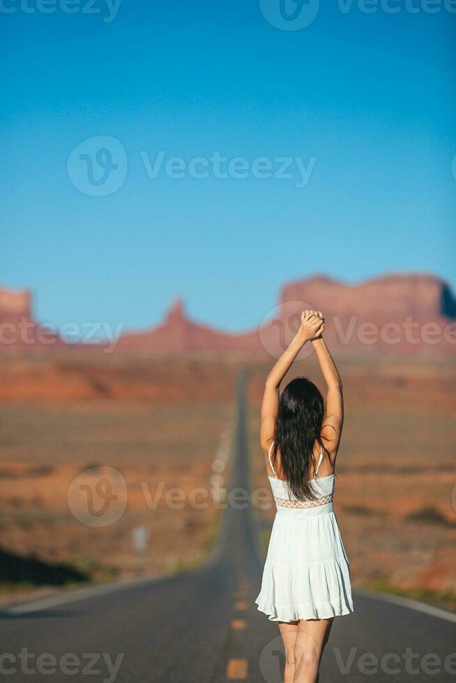 Lycklig ung kvinna på de känd väg till monument dal i utah på henne resa i känd kanjon i usa. Fantastisk se av de monument dal. foto