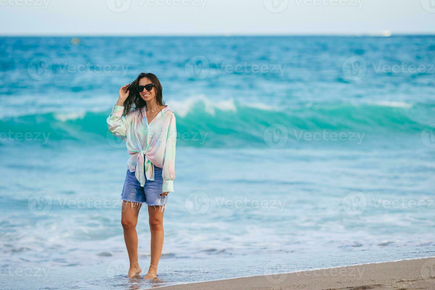 ung Lycklig kvinna gående på de strand foto
