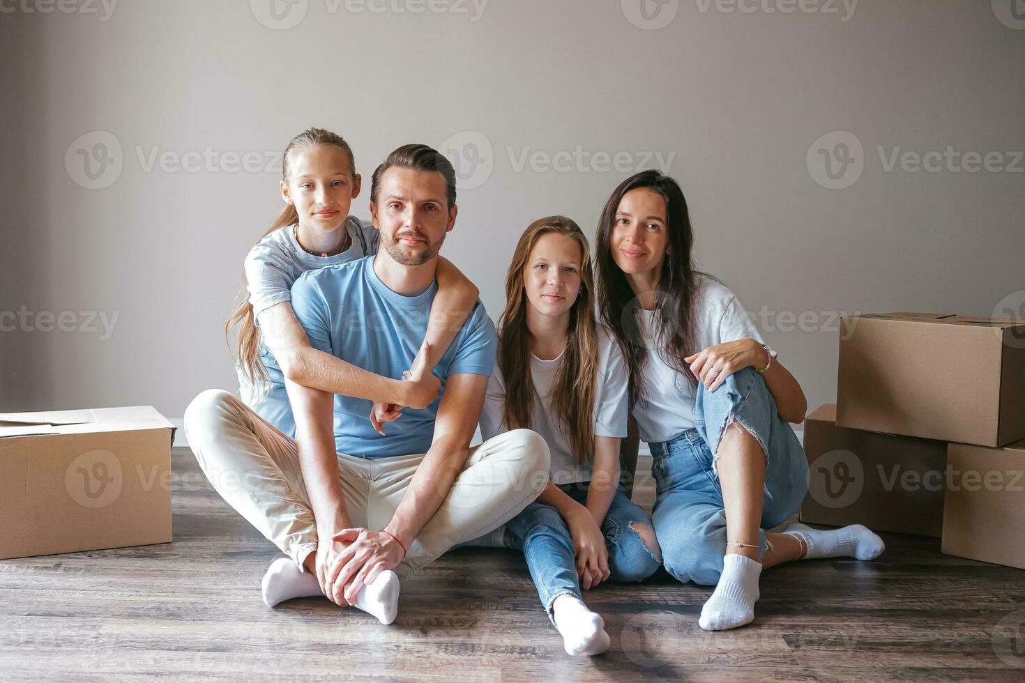 Lycklig familj med två döttrar ha roligt i deras ny Hem. förälder med barn njut av deras rör på sig dag foto