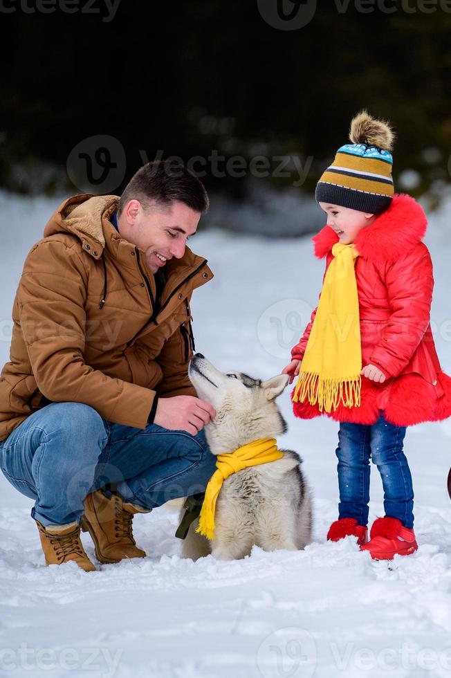 far med dotter på en promenad i skogen, husky othes på vintern. foto