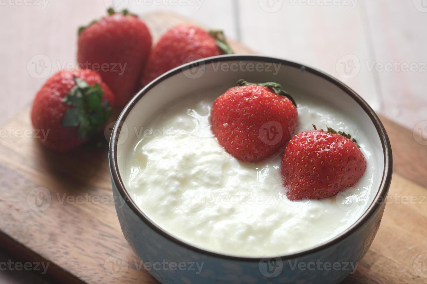 färsk jordgubbe och yoghurt i en skål på bordet foto