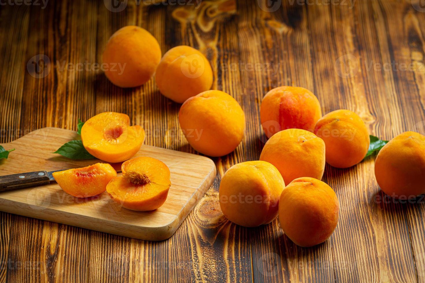 persikor placeras på en träskiva. foto