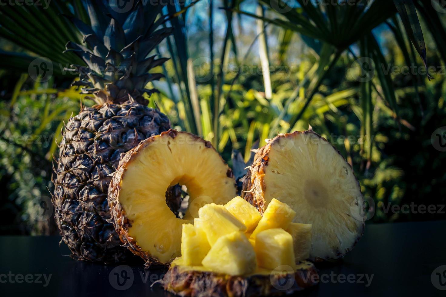 skivad ananas framför palmer foto