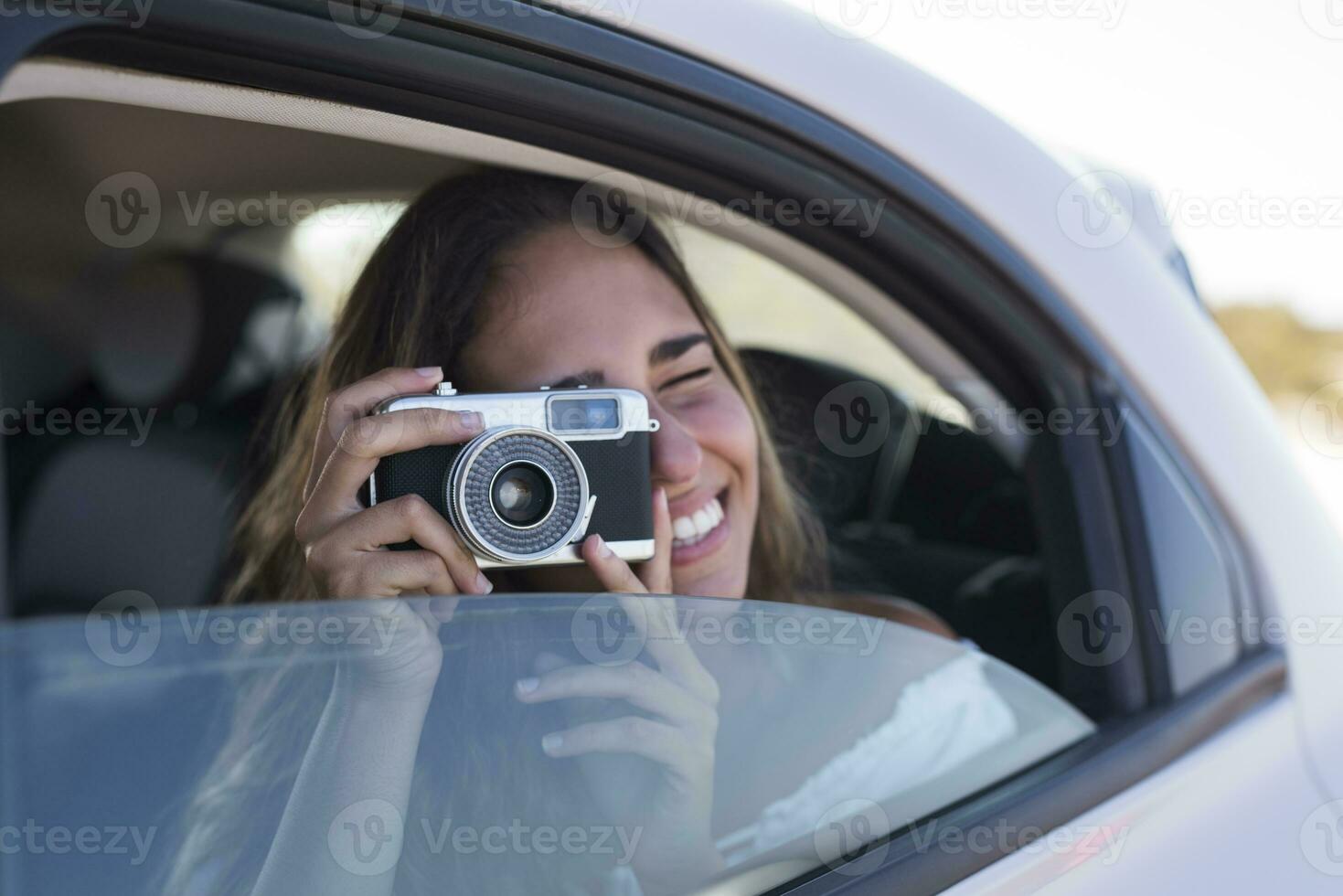 kvinna Sammanträde i bil, tar bilder med en kamera foto