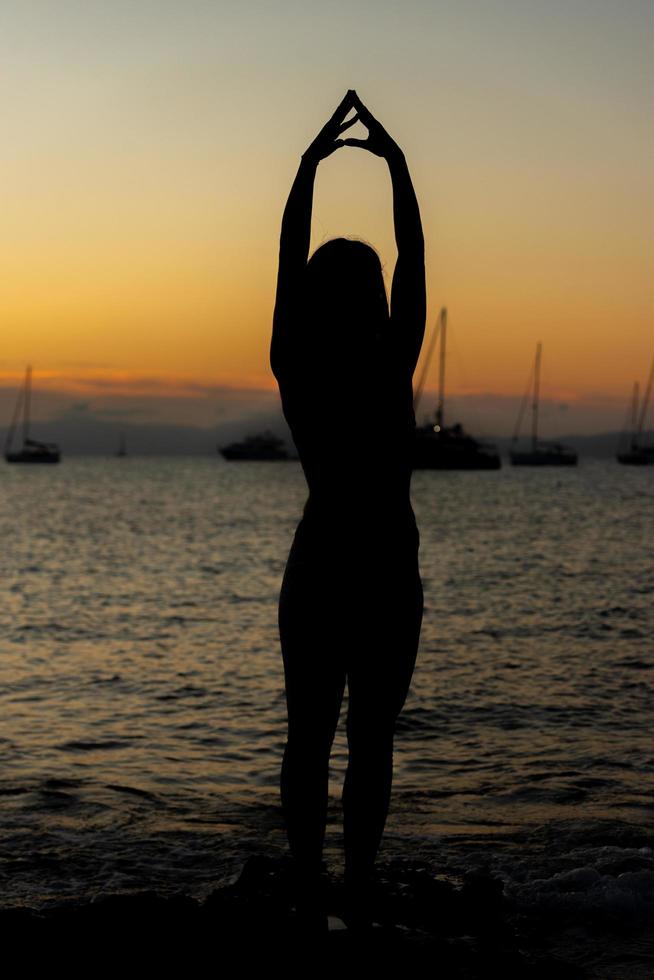 kvinna som övar yoga på stränderna i formentera i Spanien foto